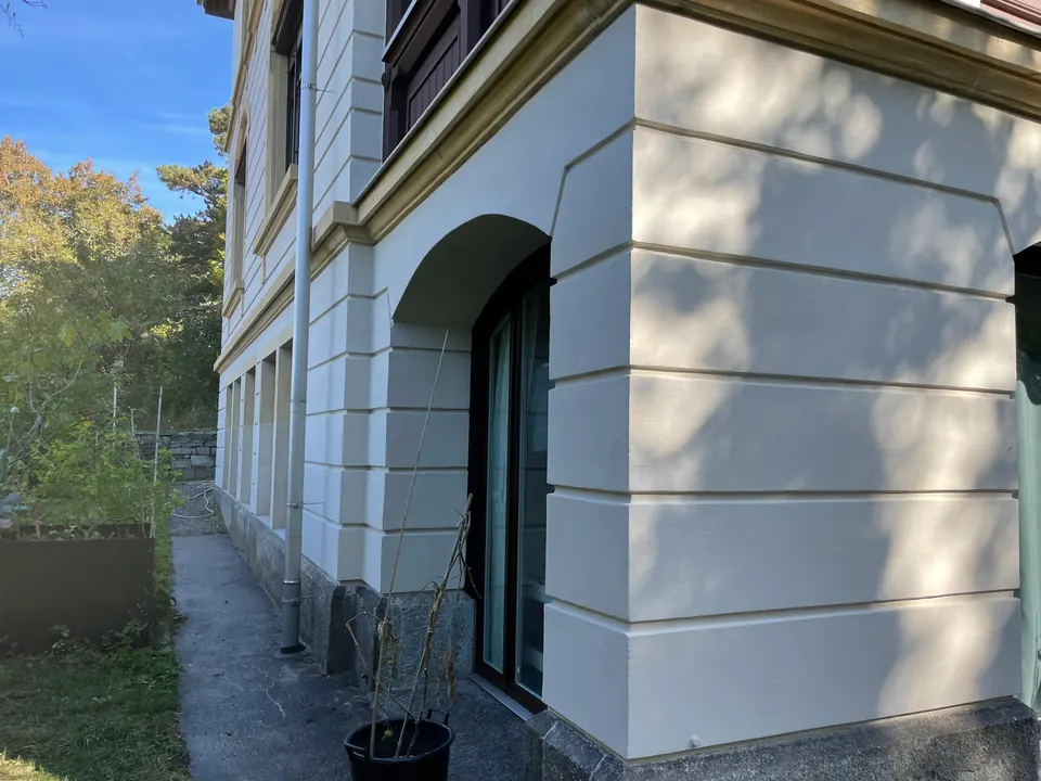 Hell gestrichene Fassade mit Lisenen und Rundbogen