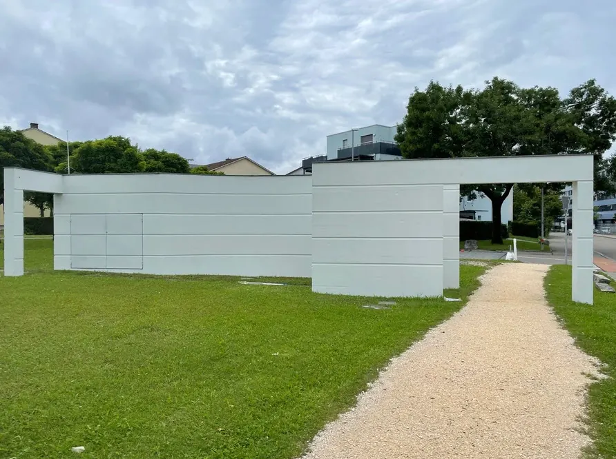 Weiss gestrichene Mauer in einer Parkanlage