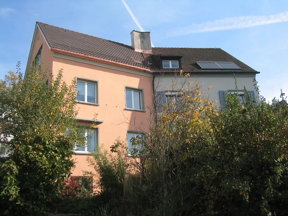 Mehrfamilienhaus mit zweifarbiger Fassade in Rosé und Grau