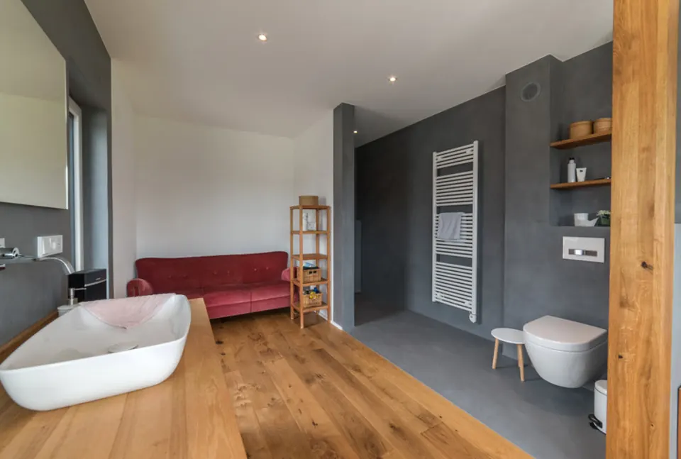 Badezimmer mit anthrazitfarbener Wand und Holzboden