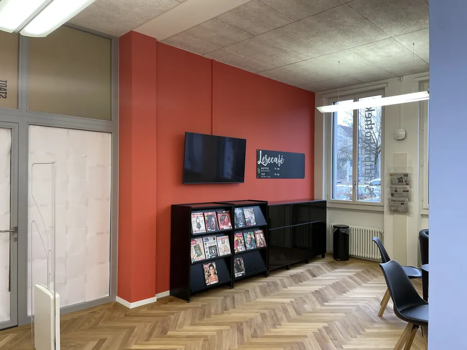 Rote Akzentwand im Lesecafé einer Bibliothek